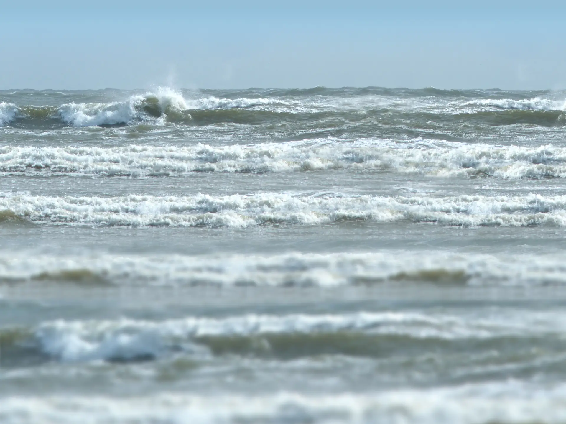 Brandingkajakken locatie met rollende golven en schuimende branding in de Noordzee.