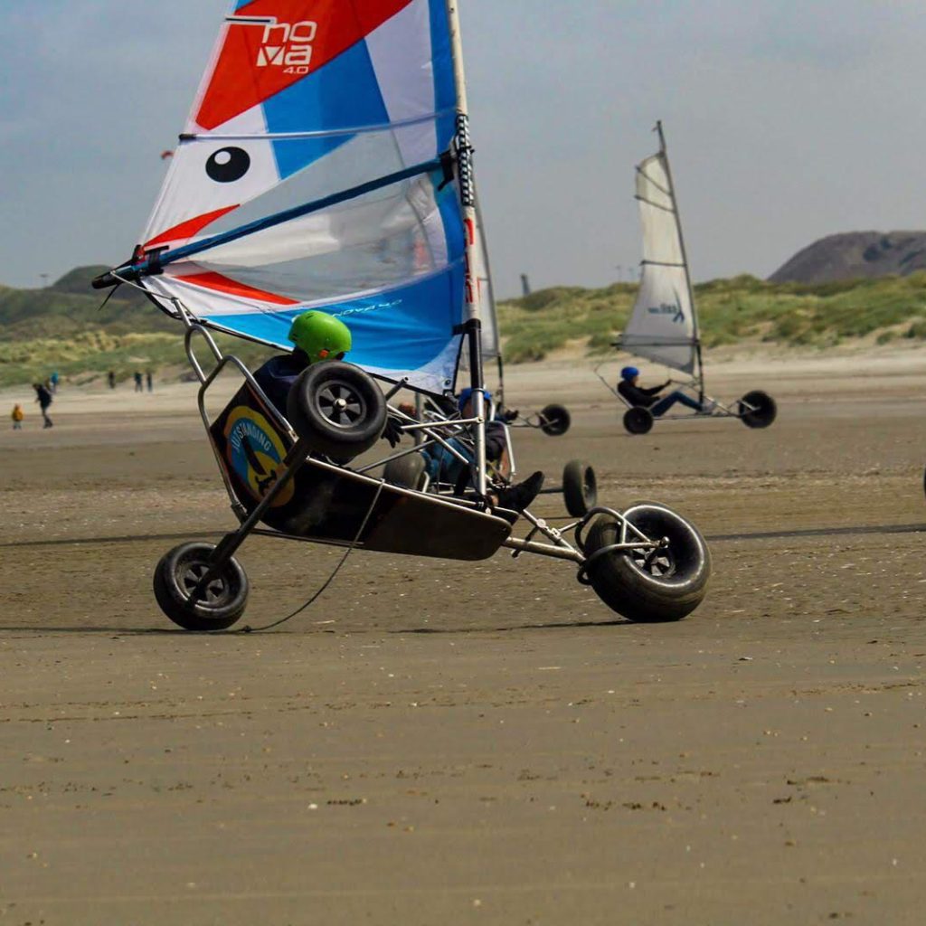 Groep collega's die blokarten als onderdeel van een bedrijfsevenement bij Outstanding op het strand